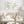 Sage green leaf branch prints above a cream boucle loveseat