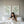 Sage green leaf wall art above a bed with white linen
