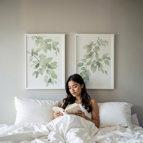 Sage green leaf wall art above a bed with white linen
