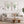 Pair of green sea fan prints in oak frames above a linen sofa and round wooden coffee table