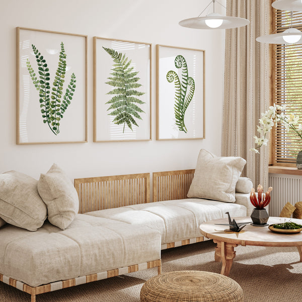 Living room with a beige sofa, framed fern prints, and a small table with decor items.
