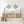 Wooden sideboard with fish artwork, lamps, and baskets in a room with white walls.