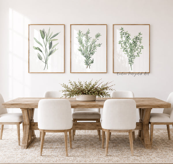 Dining room with wooden table and white chairs, featuring framed botanical prints showing kitchen herbs thyme rosemary and sage on the wall.