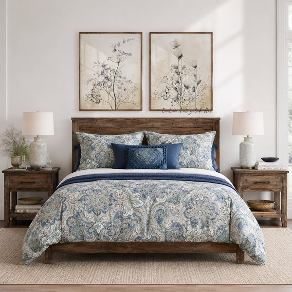 Pair of vintage wildflower prints above a bed with blue paisley bedding