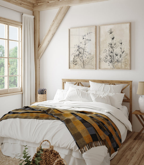 Vintage wildflower prints above a wooden bed under exposed ceiling beams