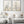 Black framed wildflower prints above a white sectional sofa