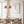 Neutral jellyfish wall art in a light wood frame above a dining table with copper pendant lamps