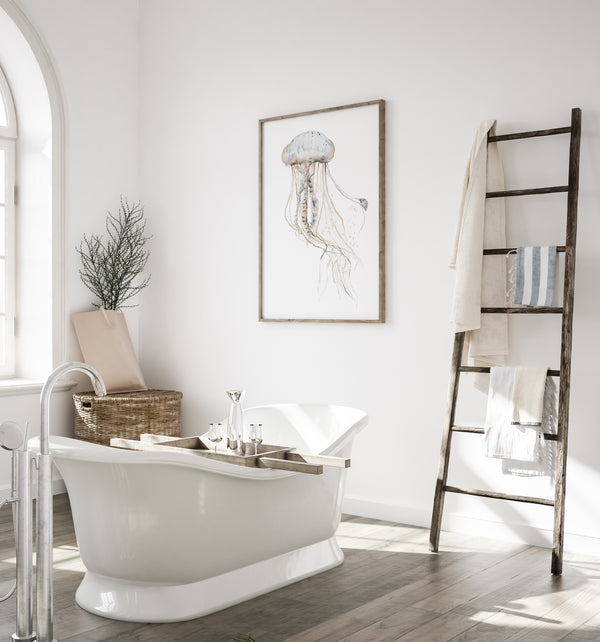 Jellyfish wall art above a freestanding bathtub in a bright coastal bathroom