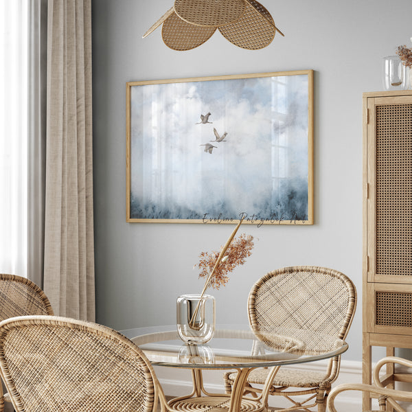 framed artwork showing japandi abstract print with flying cranes on the wall in a room with a round glass table and chairs.