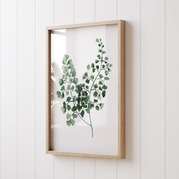 minimalist green fern leaf painting hangs in wooden frame viewed from an angled perspective 