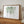 watercolor hanging plant eceropegia in green is put into wooden mat frame and stands on a buffet leaning towards left