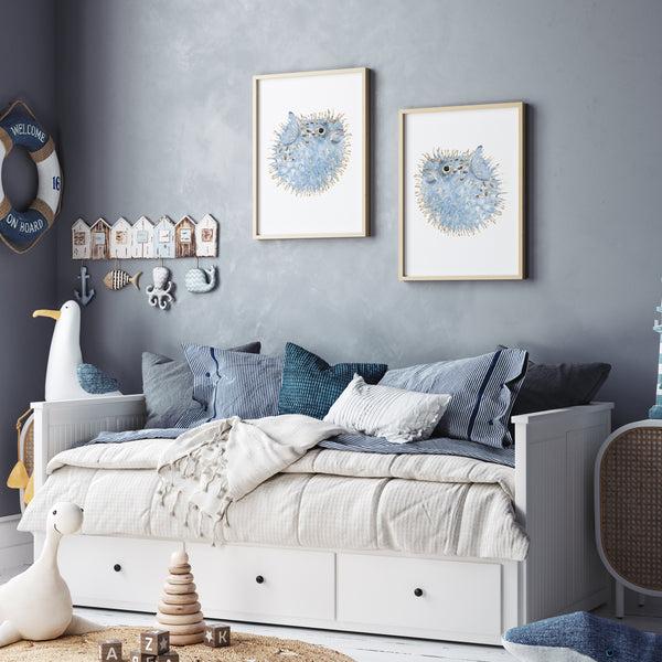 Set of 2 blue puffer fish wall art prints in wooden frames – coastal watercolour sea life artwork styled above daybed in nautical-themed kids room with grey walls and marine decor