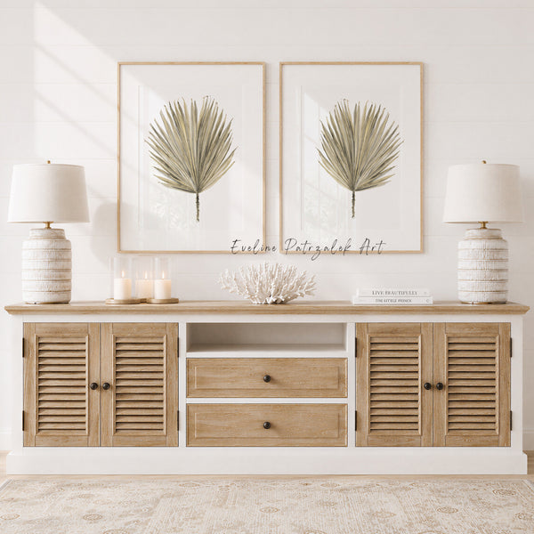 Wooden console table with decorative items and palm leaf art in a bright room.