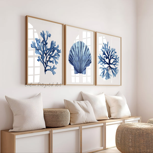 Nautical-themed wall art with blue coral and shell designs in deep navy blue against white background in a living room setting decorated in beige neutral colors.