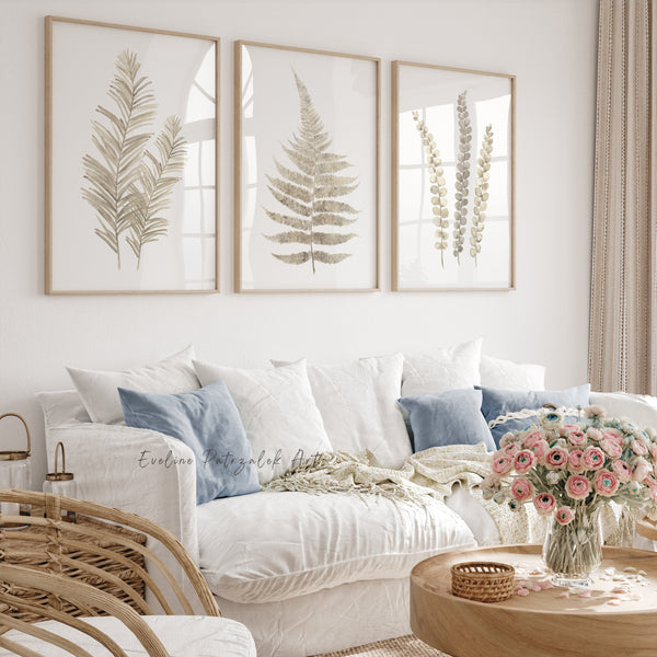Cozy living room with a white sofa, framed botanical prints, and a wooden coffee table with flowers.