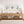 Wooden console table with decorative items against a wall with floral hydrangea prints.