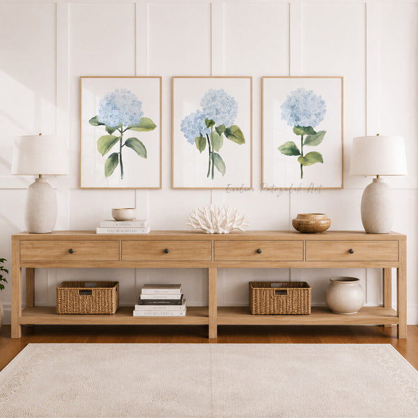 Wooden console table with decorative items against a wall with floral hydrangea prints.