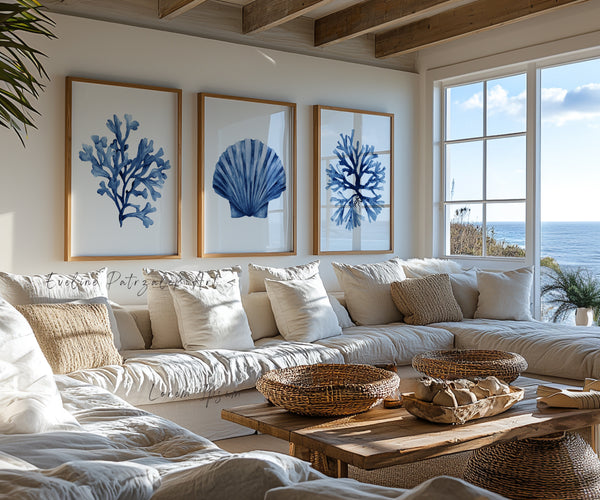 Living room with coastal decor featuring blue coral and shell prints, a large window with ocean view, and a beige sofa.