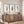 Three framed botanical art prints with green leaf illustrations hang above a rustic wooden sideboard in a bright, modern room with natural light.